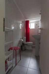 a bathroom with a toilet sink and a red shower curtain at Mario's Apartment in Neos Marmaras