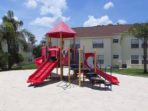 un parque infantil en la arena frente a un edificio en Great Lovely Family Apartment close Disney, en Kissimmee