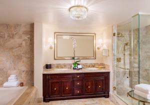 a bathroom with a tub, toilet, sink and mirror at Trump National Doral Golf Resort in Miami