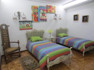 a bedroom with two beds and a chair in it at CASA DE JULIO MARROQUIN in Pradoluengo