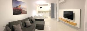 a living room with a couch and a flat screen tv at Apartamento Playa Elisa in Pilar de la Horadada