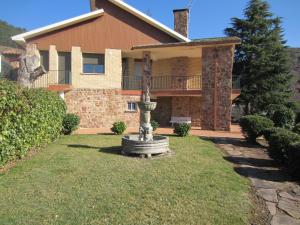 a large house with a fountain in the yard at CASA DE JULIO MARROQUIN in Pradoluengo
