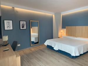 a bedroom with a large bed and a mirror at Hotel Puerta del Mar - Adults Recommended in Nerja