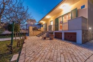 a house with a brick driveway in front of it at Holiday House Lavanda in Vrsi
