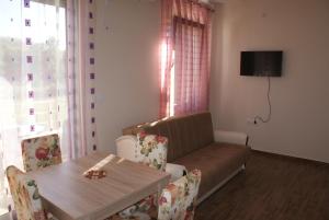 a living room with a couch and a table with chairs at Helena Apartments in Ulcinj