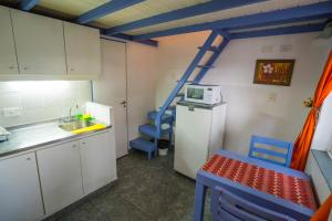 a small kitchen with a refrigerator and blue chairs at Villa Crespo Arena in Buenos Aires