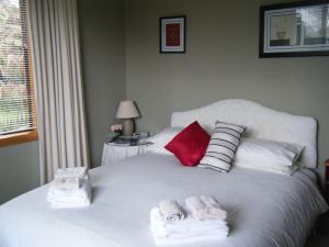 Un dormitorio con una cama blanca con toallas. en TWYNHAM at Kinloch en Kinloch