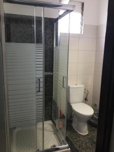 ein Bad mit einem WC und einer Glasdusche in der Unterkunft Central House with AmazingView in Kavala