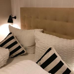 a bed with white pillows and a headboard at Gasthaus Schwanen & Villa Pfarrhus in Stühlingen