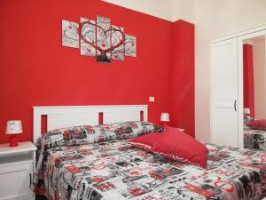 ein rotes Schlafzimmer mit einem Bett und einer roten Wand in der Unterkunft La Gramigna Villette in Briatico
