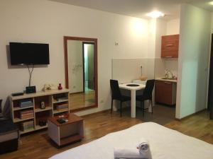 Zimmer mit einem Bett und einem Schreibtisch mit einem Tisch in der Unterkunft Apartment Bono 1 City Kvart in Podgorica