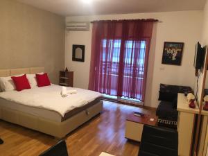 a bedroom with a bed with red pillows at Apartment Bono 1 City Kvart in Podgorica