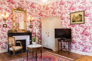 un soggiorno con carta da parati floreale rosa di Château de Beauvais a Azay-sur-Cher