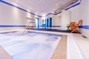 einen Pool in einem Zimmer mit blauen und weißen Wänden in der Unterkunft Hotel Auditorio Santiago & Spa in Lugo