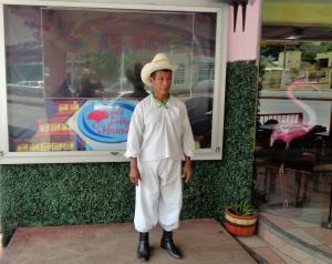 a man wearing a hat standing in front of a store at Hotel Esmeralda in Poza Rica de Hidalgo