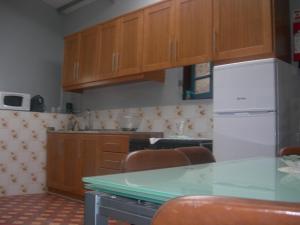 uma cozinha com armários de madeira e um frigorífico branco em D. Maria São Pedro de Balsemão em Lamego