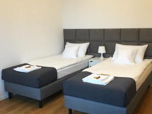 Dos camas en una habitación de hotel con toallas. en Vista Residence Premium en Varsovia