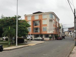 um edifício ao lado de uma rua com carros em Colon Plaza Hotel em Tumaco
