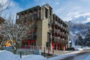 a building in the mountains with snow on the ground at Hotel Ambrosini in Aprica