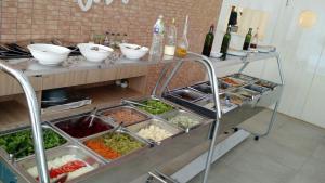 a buffet with lots of food and bottles of wine at Condado Aldeia dos Reis 205 e 213 in Mangaratiba