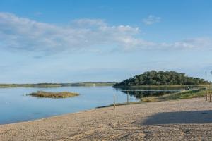 un cuerpo de agua con una isla a lo lejos en Horta Da Coutada en Monsaraz