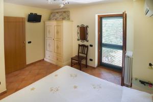 a bedroom with a bed and a chair and a window at Il Glicine in Cetara