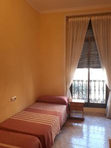 1 dormitorio con cama y ventana grande en Hostal Pacios, en Madrid