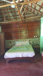 a bed in a small room with a wooden floor at Villa La Caleta in Las Galeras