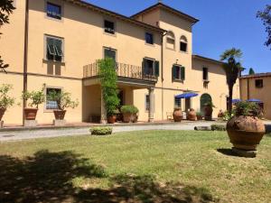 un gran edificio con un gran jarrón en un patio en Agriturismo La Palazzina, en Palaia