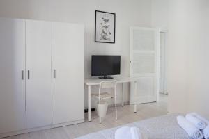 Habitación blanca con escritorio y monitor de ordenador en Cleo Giglio, en Ancona