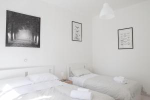 2 camas en una habitación con paredes blancas en Cleo Giglio en Ancona