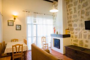 a living room with a fireplace and a table and chairs at Los Chendas in Villanueva de Ávila