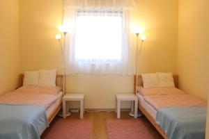 Pokój z 2 łóżkami pojedynczymi i oknem w obiekcie Platán Vendégház w mieście Csemő