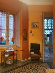 een woonkamer met een tv en 2 ramen bij Green Tricolore in Milaan