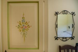 a mirror on a wall with a flower on it at Il Glicine in Cetara