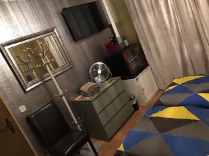 een slaapkamer met een bed en een bureau met een ventilator bij Messe Apartment & Rooms Hänigsen in Hänigsen
