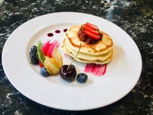 a plate with pancakes and fruit on a table at Beaconsfield Bed and Breakfast - Victoria in Victoria