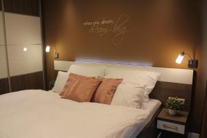 A bed or beds in a room at Olive Apartman