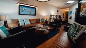 a living room with leather couches and a table at Feather Factory Hotel in Queens