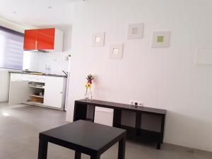 a kitchen with a desk and a table in a room at Casa Io - Goraz in Mindelo