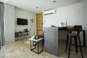 a living room with a kitchen with a counter and stool at Siambeach Resort in Cha Am