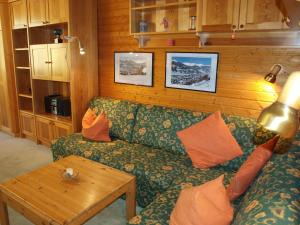 a living room with a green couch and a table at Kurpark Appartements in Bad Hofgastein