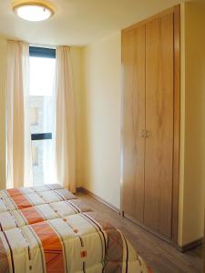 a bedroom with a bed and a large window at Aparthotel Nou Vielha in Vielha