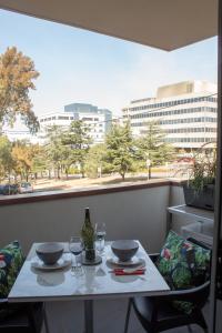 a table with glasses and a bottle of wine on a balcony at Centrepoint Units Heidelberg in Melbourne