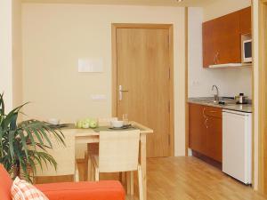 a kitchen with a table and a dining room at Aparthotel Nou Vielha in Vielha