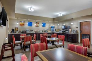 a restaurant with tables and chairs and a bar at Comfort Inn South Chesterfield - Colonial Heights in Colonial Heights