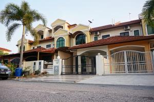 a large house with a gate and a palm tree at Warisan Indah Homestay KLIA 2 Melayu sahaja in Sepang