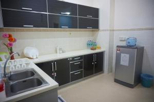 uma cozinha com um lavatório e um frigorífico em Warisan Indah Homestay KLIA 2 em Kampong Melot