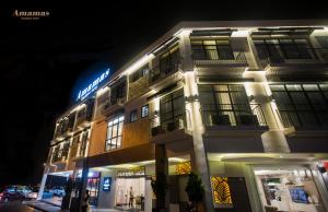 古晉的住宿－Amamas Boutique Hotel Kuching，一座建筑物,上面有夜间标志