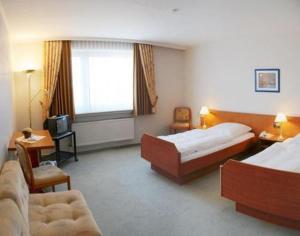 a hotel room with two beds and a television at Wehrmann-Blume in Wunstorf